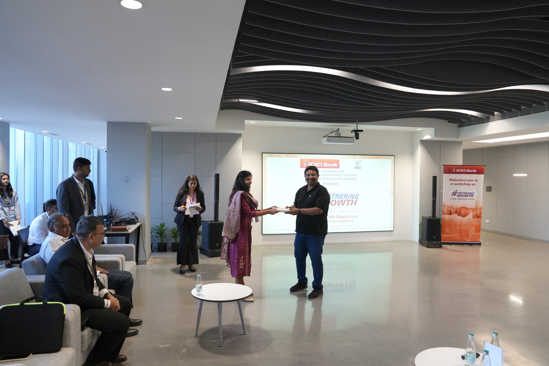 A participant is presented with a token of appreciation at the close of the session.